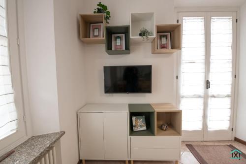a living room with a tv on a wall at Attico Varese centro - Ixihome in Varese