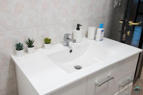 a white sink in a bathroom with plants on it at Attico Varese centro - Ixihome in Varese