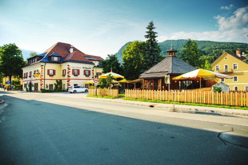 ulica w mieście z ogrodzeniem i budynkami w obiekcie Hotel-Gasthof Weitgasser w mieście Mauterndorf