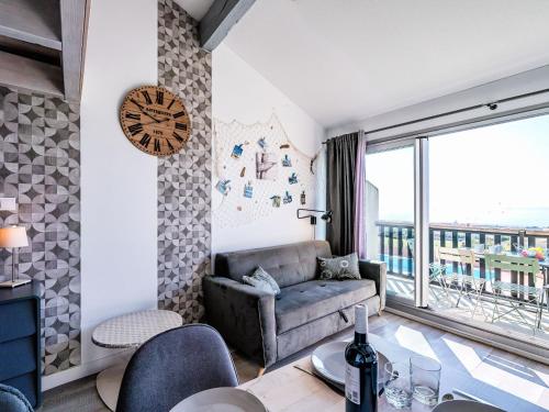 een woonkamer met een bank en een groot raam bij Apartment Les Eaux Vives 1 & 2-2 by Interhome in Saint Pierre La Mer