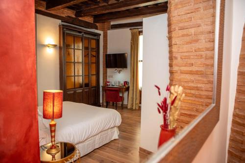 una camera da letto con un letto e un tavolo con una lampada di Hotel Boutique Posada Castañeda a Granada