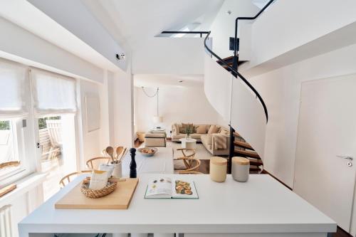 a room with white walls and a white table at Vier Häuser in Norderney
