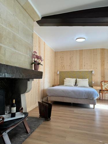 a bedroom with a bed and a fireplace at Chateau Eck in Cadaujac