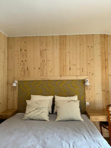 a bedroom with a bed with wooden walls at Chateau Eck in Cadaujac
