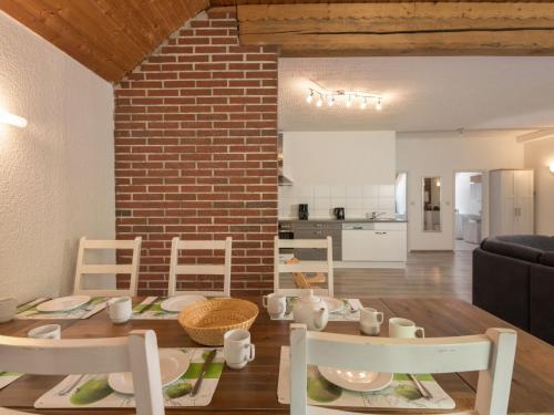 a dining room and living room with a table and chairs at Apartment Eifelnatur - Haus 2-2 by Interhome in Immerath