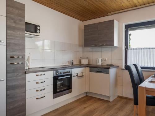 a kitchen with white appliances and a table and a window at Apartment Eifelnatur - Haus 2-1 by Interhome in Immerath