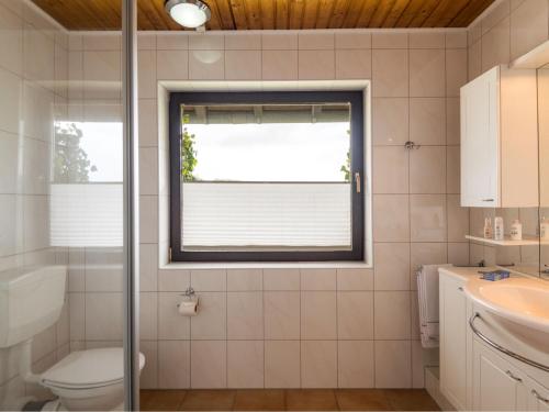 a bathroom with a toilet and a window at Apartment Eifelnatur - Haus 2-1 by Interhome in Immerath