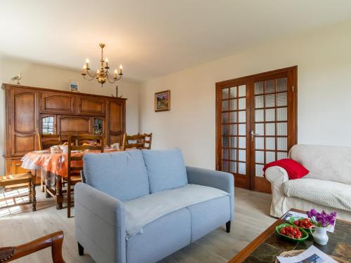 un salon avec un canapé bleu et une table dans l'établissement Holiday Home Ar Wellen by Interhome, à Cléder