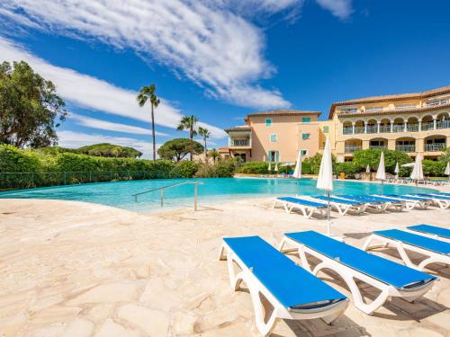 une piscine avec des chaises longues et un complexe hôtelier dans l'établissement Apartment Les Rivages des Issambres-8 by Interhome, aux Issambres