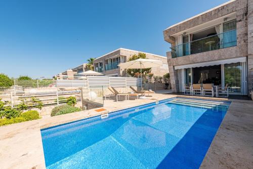 a swimming pool in front of a house at Villa Olea ZadarVillas in Petrcane