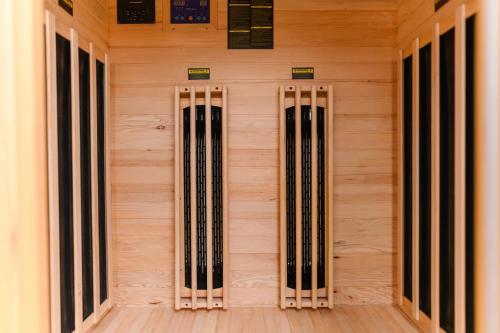 a wooden wall with four doors in a room at SPA apartman Tomin adults only in Soko Banja