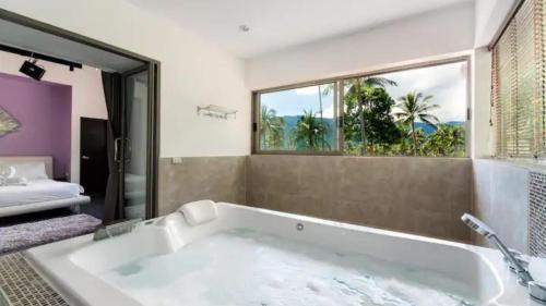 a bath tub in a bathroom with a window at Villa VV Lamai Koh Samui in Koh Samui 