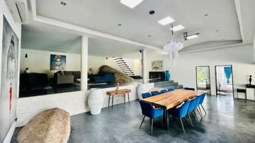 a living room with a wooden table and blue chairs at Villa VV Lamai Koh Samui in Koh Samui 