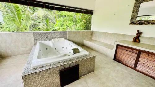 a bathroom with a bath tub and a large window at Villa VV Lamai Koh Samui in Koh Samui 
