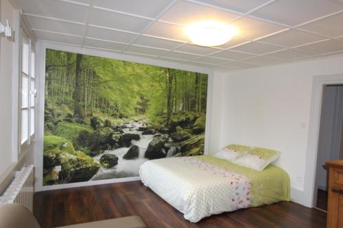 a bedroom with a painting of a river at L'Appartement - Cœur de Riquewihr - 2 à 4 personnes in Riquewihr