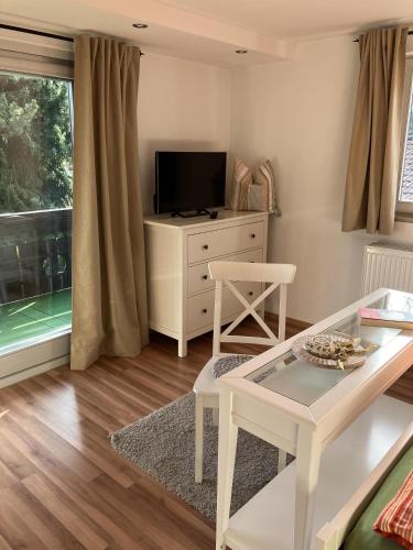 a living room with a tv and a table at Der Sonnenhof - Ferienwohnungen in Obermaiselstein