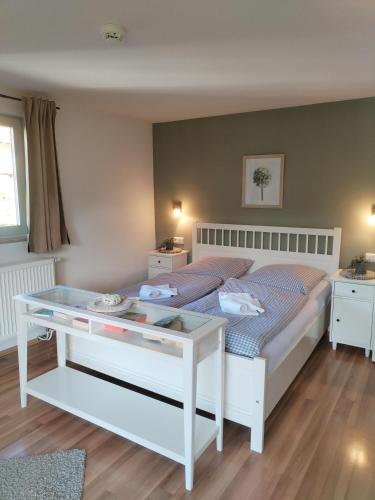 a bedroom with a bed with a glass table at Der Sonnenhof - Ferienwohnungen in Obermaiselstein