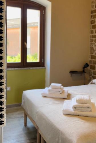 a room with two towels on a bed with a window at Casa Gioconda Bed & Breakfast in Nuxis