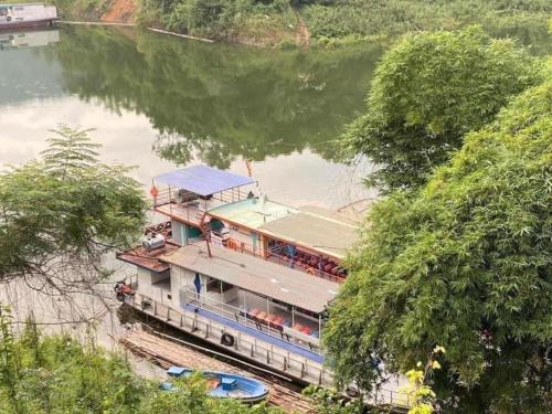 a boat in the middle of a river at Halo Retreat in Hòa Bình