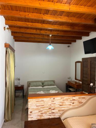 a bedroom with a bed and a wooden ceiling at Avgerinou Studios in Paliochori
