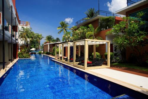 a swimming pool in front of a building at La Flora Resort Patong in Patong Beach