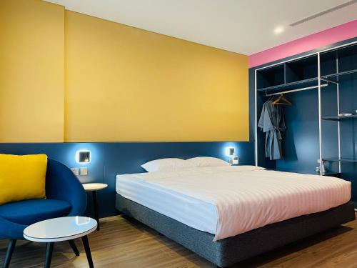 a bedroom with a bed and a blue and yellow wall at Hải Tiến Be Home in Hoằng Hóa