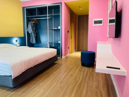 a bedroom with a bed and a pink wall at Hải Tiến Be Home in Hoằng Hóa