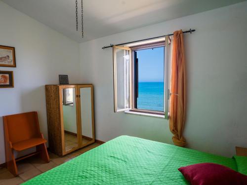 a bedroom with a green bed and a window at Apartment Stelle by Interhome in Trappeto