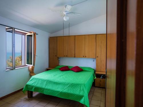 a bedroom with a green bed with a window at Apartment Stelle by Interhome in Trappeto