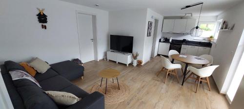 a living room with a couch and a table and a kitchen at Irgendwo im Schwarzwald in Elzach