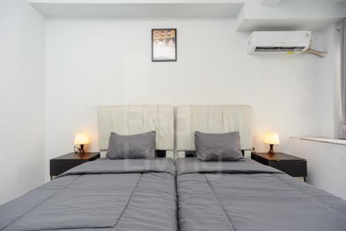a bedroom with two beds and two lamps on tables at RedLiving Apartment Patra Land Urbano - Alfa Rooms Tower East in Bulanbulan