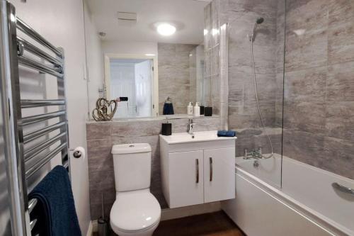 a bathroom with a toilet and a sink and a shower at 2 bedroom apartment in Stratford upon Avon with free onsite parking in Stratford-upon-Avon