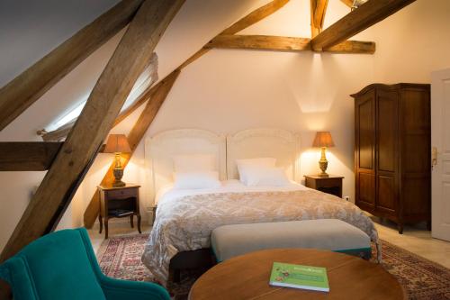 a bedroom with a bed and a table and chairs at Aux Charmes de Maintenon in Maintenon