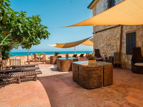 eine Terrasse mit Tischen und Stühlen und einem Sonnenschirm in der Unterkunft Apartment Luna by Interhome in Trappeto