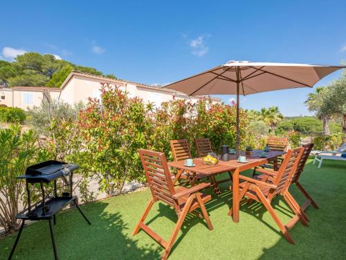 une table et des chaises avec un parasol et un grill dans l'établissement Apartment Les Eucalyptus-12 by Interhome, à Saint-Aygulf