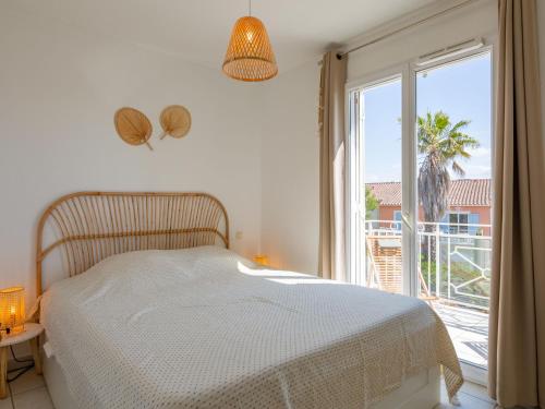 une chambre avec un lit et une grande fenêtre dans l'établissement Apartment Les Eucalyptus-12 by Interhome, à Saint-Aygulf