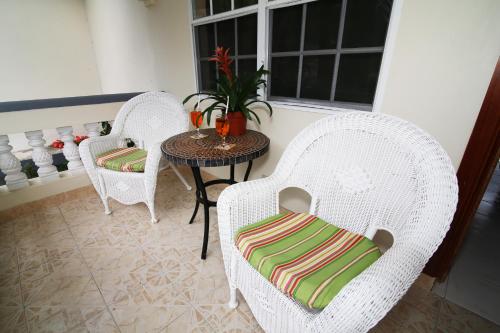 two wicker chairs and a table in a room at Rayon Hotel in Negril