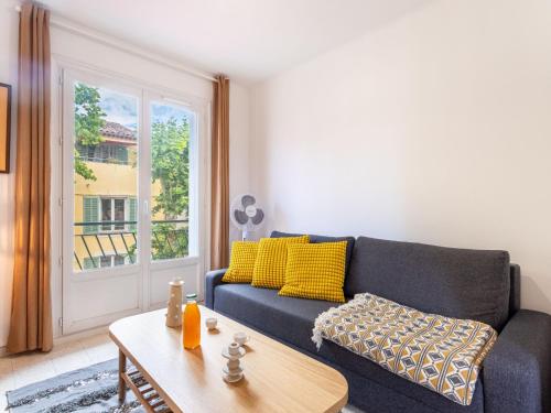 un salon avec un canapé bleu et une table dans l'établissement Apartment Le Coquillon by Interhome, à Sanary-sur-Mer