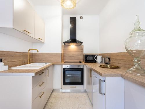 une cuisine avec des armoires blanches et des comptoirs en bois dans l'établissement Apartment Le Coquillon by Interhome, à Sanary-sur-Mer