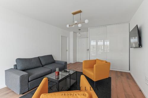 un salon avec un canapé et une chaise dans l'établissement KAZA BELLA - Saint Ouen Beautiful apartment, à Saint-Ouen