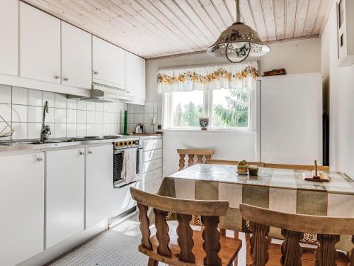 a kitchen with white cabinets and a table and chairs at Holiday Home Alice by Interhome in Tällberg