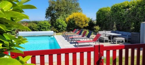 a row of chairs and tables next to a pool at Le clos du Verdelet vue mer piscine in Planguenoual