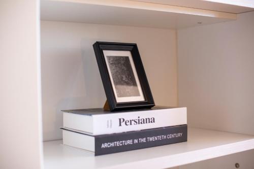 a picture frame on top of books on a shelf at PISO EN COMBARRO A 1º LINEA DE COSTA in Combarro
