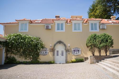 a large yellow house with a white door at Glicínia Boutique Hotel in Freamunde