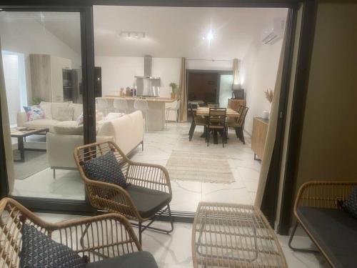 a living room with chairs and a living room with a kitchen at Le Jacquier Life House in Saint-Pierre