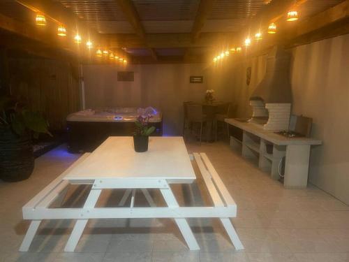 a room with a table and a bench and a tub at Le Jacquier Life House in Saint-Pierre