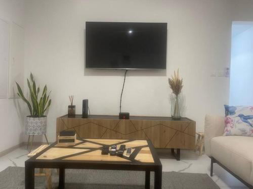 a living room with a coffee table and a flat screen tv at Le Jacquier Life House in Saint-Pierre