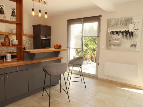 une cuisine avec deux tabourets, un comptoir et une fenêtre dans l'établissement Holiday Home Cremiou Beach by Interhome, à Kerlouan