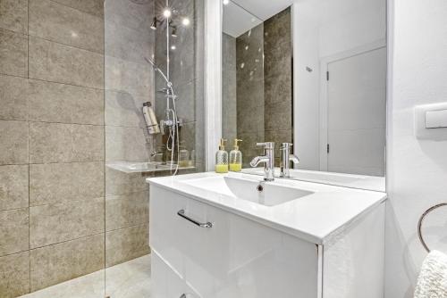a white bathroom with a sink and a mirror at Senna in Jávea