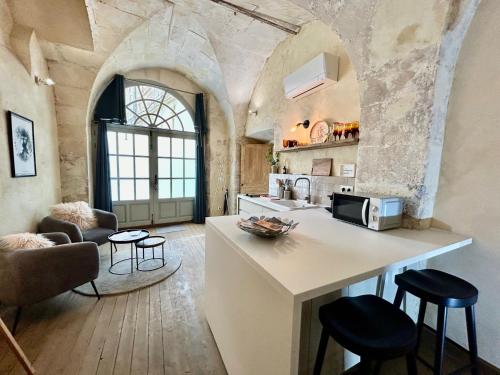 une cuisine avec un comptoir et des tabourets dans une pièce dans l'établissement Les écuries de Lestang-Parade, à Arles